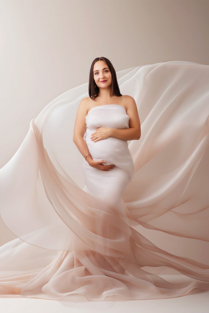 Pregnant woman in a flowing dress during a maternity photoshoot in a professional studio in Preston, Lancashire.