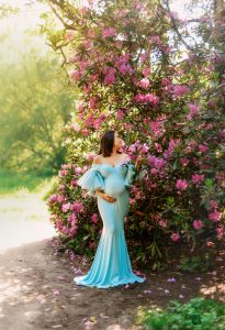 Expectant mother in a beautiful garden, holding her belly during an outdoor maternity photoshoot in Preston, Lancashire.