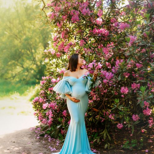 Expectant mother in a beautiful garden, holding her belly during an outdoor maternity photoshoot in Preston, Lancashire.