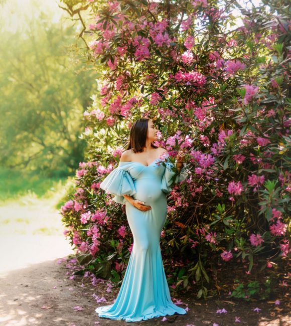 Expectant mother in a beautiful garden, holding her belly during an outdoor maternity photoshoot in Preston, Lancashire.