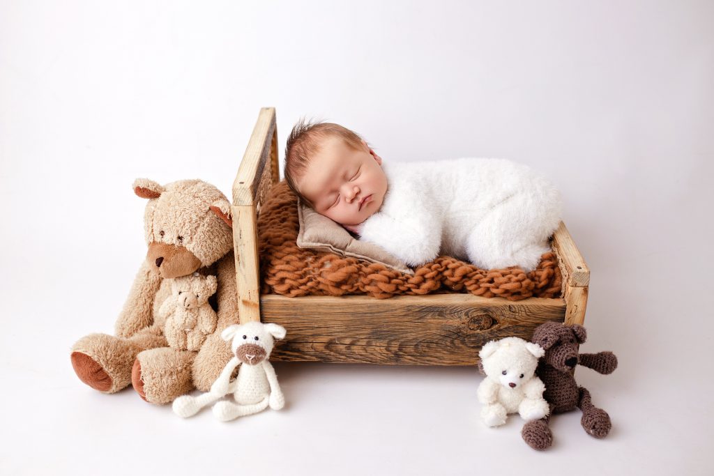 baby boy photoshoot in preston lancashire, baby on the wooden bed with teddies around