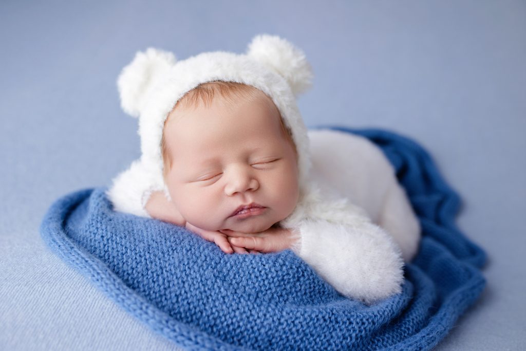 newborn photoshoot preston lancashire, baby boy posed on the blue background