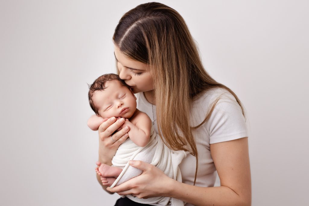 mommy kissing baby on the head on the newborn photoshoot in preston, lancashire
