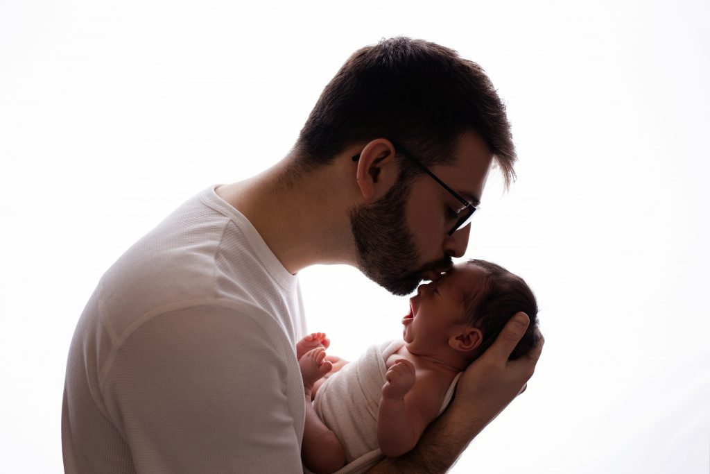 daddy holding baby on the newborn photoshoot
